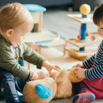 children play with a teddy bear