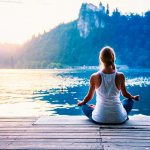 girl meditating by the water