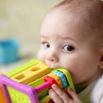 Baby chewing on a toy