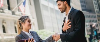 A man in a business suit smiles while holding the hand of a girl in a jacket