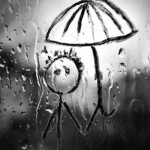 Drawing of a man in the rain on a window glass