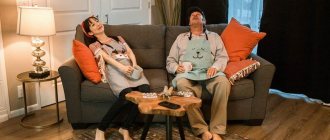 Tired married couple in home clothes sitting on the sofa with cups of tea